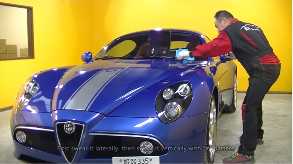 Profissional aplicando o Ceramic Coating Kisho em um Alfa Romeo, destacando a importância da aplicação técnica para a durabilidade.]